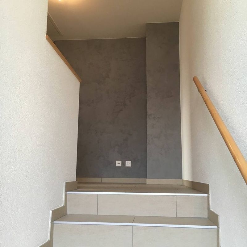 Cage d'escalier aux murs en stucco réalisée par Strueby Peinture